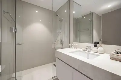 a bathroom with a sink and a glass shower at Mahogany 9 - 2BR 10PAX - Walk to Burj & Dubai Mall in Dubai