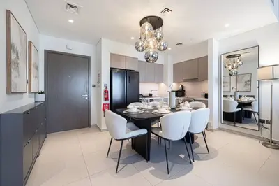 a kitchen and dining room with a black table and white chairs at Mahogany 9 - 2BR 10PAX - Walk to Burj & Dubai Mall in Dubai