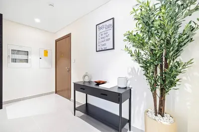 a black desk in a room with a potted plant at Mahogany 8 - 4BR 14PAX - Burj Khalifa View Central in Dubai