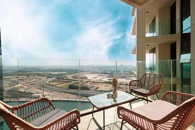 a balcony with chairs and a table with a view at Mahogany 3 - 2BR 6 Guests - Pool & Prime Location in Dubai