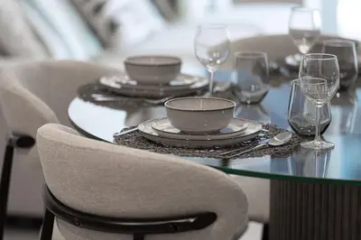 a table with plates and wine glasses on it at Mahogany 3 - 2BR 6 Guests - Pool & Prime Location in Dubai