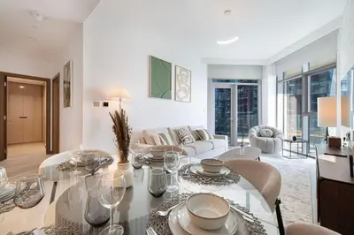 a living room with a table and chairs at Mahogany 3 - 2BR 6 Guests - Pool & Prime Location in Dubai