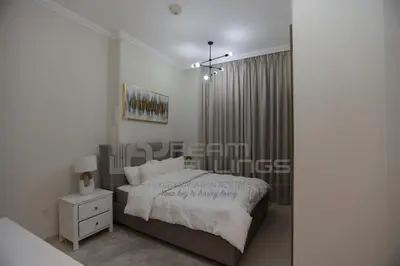 a white bedroom with a bed and a window at Downtown Dunya Tower in Dubai