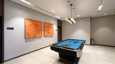a room with a pool table and paintings on the wall at Elegant Downtown Retreat in Dubai