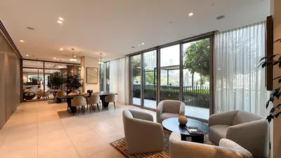 a living room with chairs and tables and windows at Elegant Downtown Retreat in Dubai