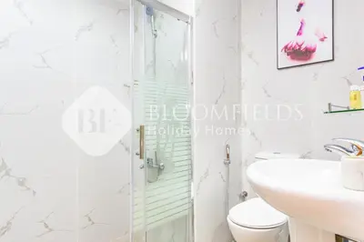 a bathroom with a shower and a toilet and a sink at Bloomfields Luxurious Stu in Mulberry 1 Emirates in Dubai