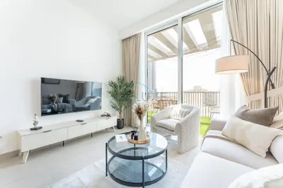 a living room with a white couch and a tv at New 1 BR with 2 Balconies Near Circle Mall, Luma22 West Tower, JVC By Deluxe Holiday Homes in Dubai
