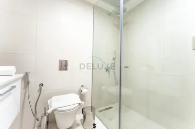 a bathroom with a toilet and a glass shower at New 1 BR with 2 Balconies Near Circle Mall, Luma22 West Tower, JVC By Deluxe Holiday Homes in Dubai