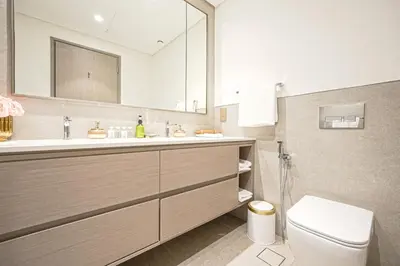 a bathroom with a sink and a toilet and a mirror at Grande Signature Residences Luxury 3BR - Burj View in Dubai Downtown in Dubai
