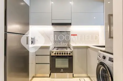 a kitchen with a stove and a refrigerator at Bloomfields Cozy 1Br In Binghatti Creek in Dubai