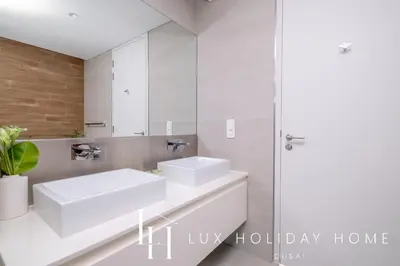 a bathroom with two sinks and a mirror at LUX The Bluewaters Island Suite 2 in Dubai
