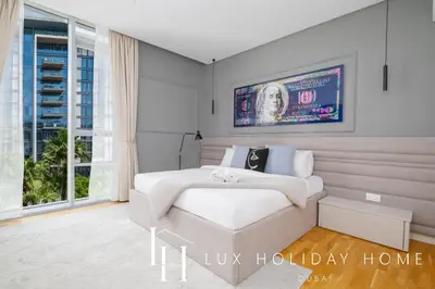 a white bedroom with a bed and a window at LUX The Bluewaters Island Suite 2 in Dubai