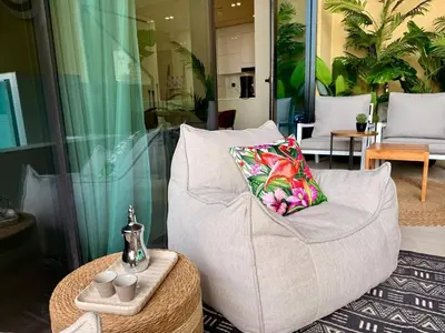 a living room with a white chair and a table at BLVD - Luxe Retreat - Stylish Stay with Full Privacy in Dubai