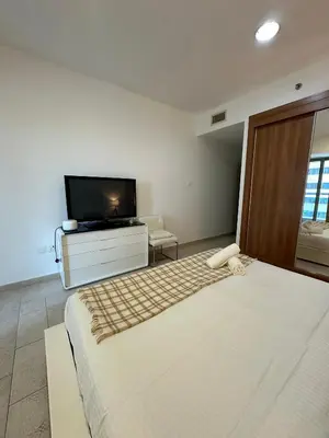 a bedroom with a large bed and a flat screen tv at Prime Marina Location Stylish Apartment in Princess Tower in Dubai
