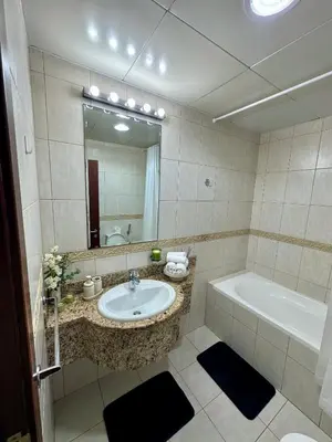 a bathroom with a sink and a tub and a mirror at Prime Marina Location Stylish Apartment in Princess Tower in Dubai