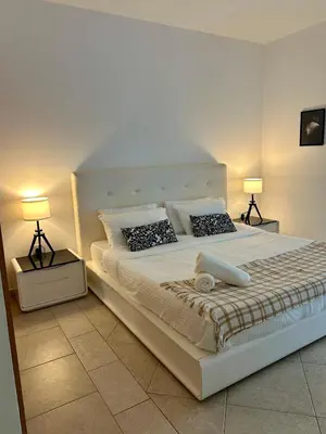 a bedroom with a large white bed with two lamps at Prime Marina Location Stylish Apartment in Princess Tower in Dubai