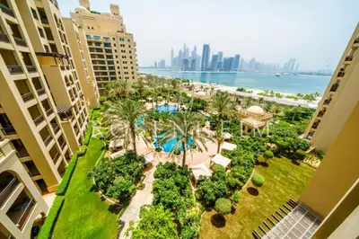 an aerial view of a resort with a pool and palm trees at Luxury Fairmont Palm - Beach Access & Sea View in Dubai
