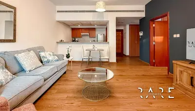 a living room with a couch and a table at Rare Holiday Homes - Near Metro Station - Greens - Al Arta - R215 in Dubai