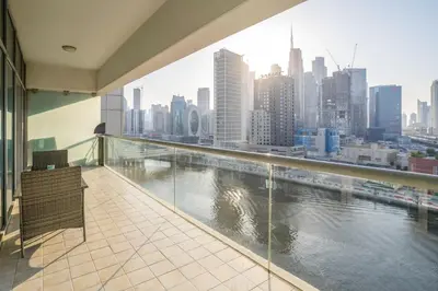 a balcony with a view of a river at Granduer 1 BR in Windsor Manor Canal Front Living With Burj Views in Dubai