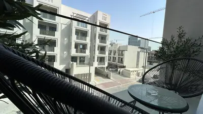 a balcony with a table and chairs and a building at Bespoke Holiday Homes - Stylish 1BR Penthouse in The Autograph in Dubai