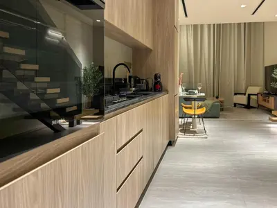 a kitchen with a large tv on a wall at Bespoke Holiday Homes - Stylish 1BR Penthouse in The Autograph in Dubai