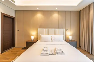 a bedroom with a large bed with towels on it at Contemporary 1BR Prime Location with Parking in Dubai