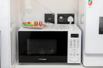 a microwave with a bowl on top of it at Celestial View 1BR apartment in JVC in Dubai