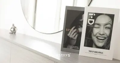 two magazines sitting on a counter next to a mirror at Elegant Luxury 1BR - Modern Design - JVC in Dubai