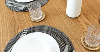 a table with a plate and two glasses on it at Elegant Luxury 1BR - Modern Design - JVC in Dubai