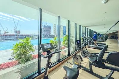 a gym with a row of treadmills and ellipticals at Stylish Studio with Jacuzzi in Business Bay in Dubai