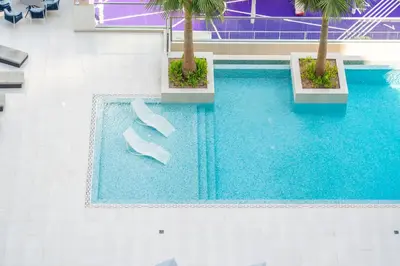 an overhead view of a swimming pool with a pair of shoes at LUX New Studio With 2 Double Beds in Downtown Dubai, Pool View, Free Parking in Dubai