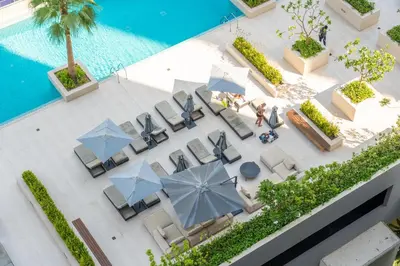 an overhead view of a pool with chairs and umbrellas at LUX New Studio With 2 Double Beds in Downtown Dubai, Pool View, Free Parking in Dubai