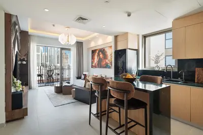a kitchen with a bar and a living room at qua Serenity Poolside with Community Views in Dubai