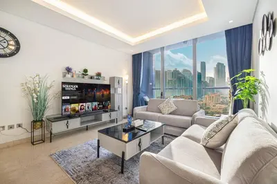 a living room with a couch and a large window at Luxe 1BR Burj View 10 min Walk to Dubai Mall in Dubai