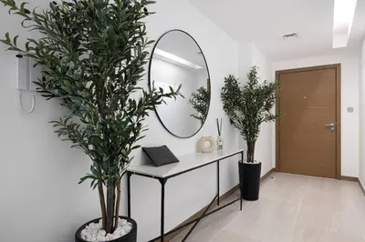 a bathroom with a mirror and two plants at Mahogany 10 - 2BR 8 PAX - Infinity Pool & Modern in Dubai