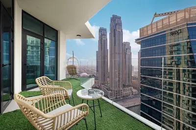 a balcony with chairs and a table on top of a building at Mahogany 10 - 2BR 8 PAX - Infinity Pool & Modern in Dubai