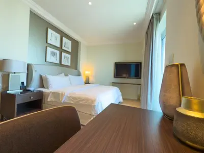 a hotel room with a bed and a table and chairs at The Address Fountain Views Residence High Floor with Burj Khalifa view and access to Dubai mall in Dubai