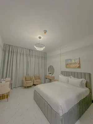 a bedroom with a large bed and a chair at Studio Apartment in Rukan Wadi Al Safa by the S Holiday Homes in Dubai