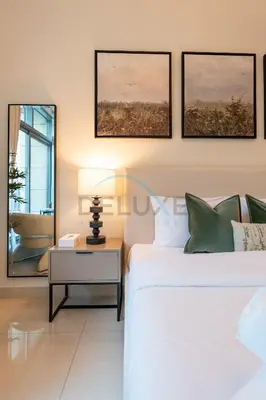 a bedroom with a bed and a table with a lamp at City View Studio, Minutes Away from Dubai Opera, Burj Khalifa and Dubai Mall, Claren Tower 2, Downtown Dubai by Deluxe Holiday Homes in Dubai