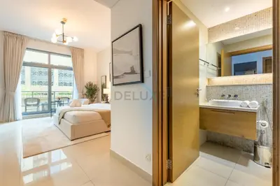 a bedroom with a bed and a bathroom with a sink at City View Studio, Minutes Away from Dubai Opera, Burj Khalifa and Dubai Mall, Claren Tower 2, Downtown Dubai by Deluxe Holiday Homes in Dubai