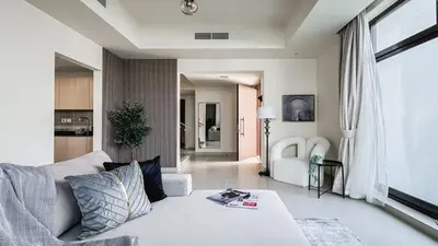 a living room with a white couch and a large window at Trophy-Lux Villa w Big Garden & BBQ Grill in Dubai