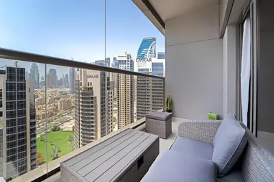 a balcony with a bench and a view of a city at 1BR with Balcony View, Gym, Pool & Kids Play Area in Dubai