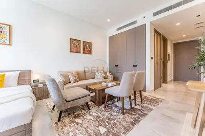 a living room with a couch and a table and chairs at Luxury Studio Steps from Dubai Canal and Minutes to Burj Khalifa, Peninsula Five - 3, Business Bay By Deluxe Holiday Homes in Dubai