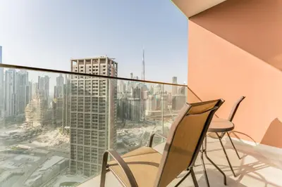 a balcony with chairs and a view of a city at Luxury Studio Steps from Dubai Canal and Minutes to Burj Khalifa, Peninsula Five - 3, Business Bay By Deluxe Holiday Homes in Dubai