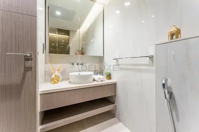 a bathroom with a sink and a mirror at Luxury Studio Steps from Dubai Canal and Minutes to Burj Khalifa, Peninsula Five - 3, Business Bay By Deluxe Holiday Homes in Dubai