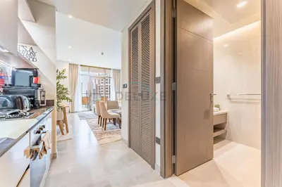 a kitchen with a door leading to a dining room at Luxury Studio Steps from Dubai Canal and Minutes to Burj Khalifa, Peninsula Five - 3, Business Bay By Deluxe Holiday Homes in Dubai