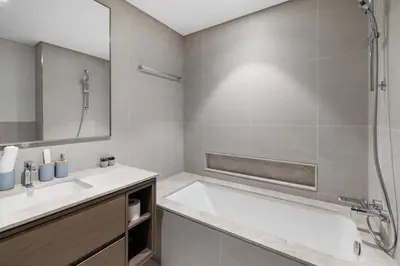 a bathroom with a tub and a sink and a shower at Luxury Stay Just Steps from Dubai Mall 2BR Grande in Dubai