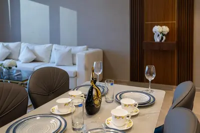 a table with plates and wine glasses and a couch at Luxury Stay Just Steps from Dubai Mall 2BR Grande in Dubai