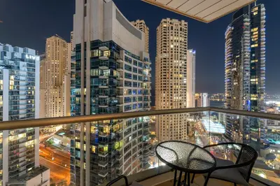 a balcony with two chairs and a view of a city at FIRST CLASS 2BR Elegant Urban Retreat in Dubai