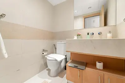 a bathroom with a white toilet and a sink at FIRST CLASS 2BR Elegant Urban Retreat in Dubai